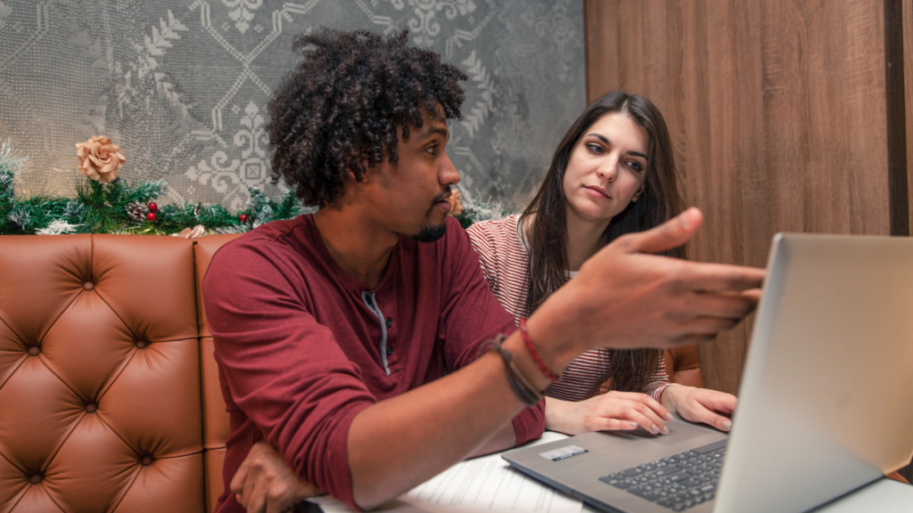 Investment Property vs. Owner-Occupied Properties - Image of man and woman looking at laptop and discussing property investment