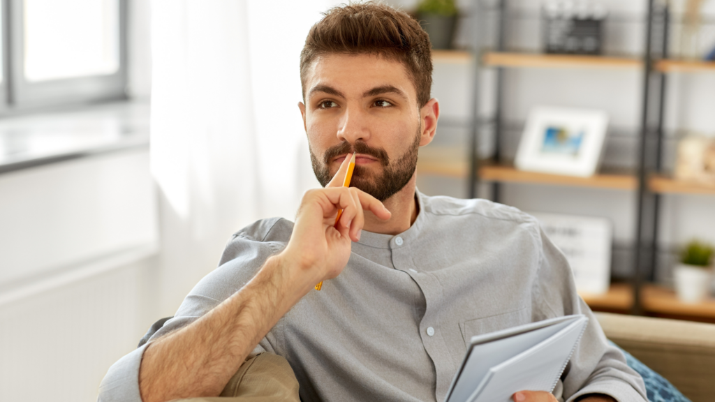 Investment Property vs. Owner-Occupied Properties - Image of man in thought considering options between investment property and owner occupied property